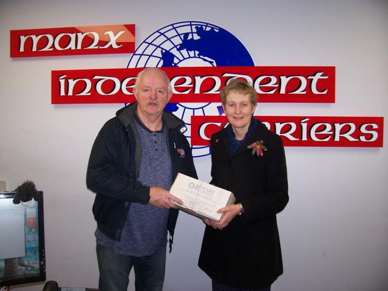 Helen is seen here delivering the shoeboxes to John Quaye, Chairman of Manx Independent Carriers who is also a member of the Rotary Club of Rushen & Western Mann