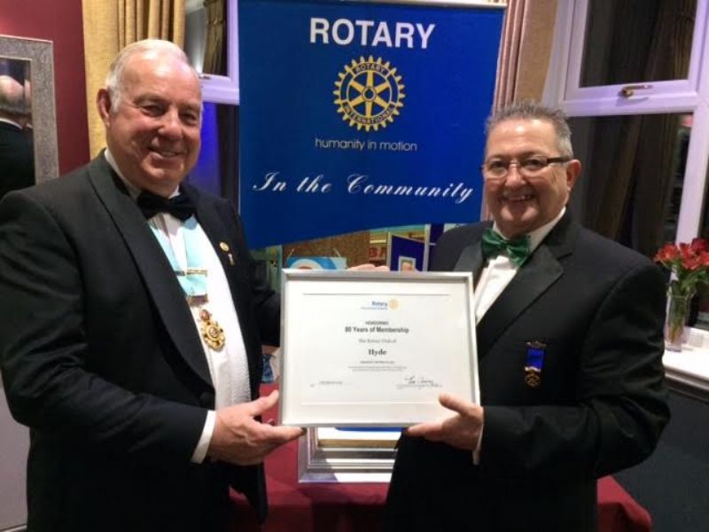 District Governor Stan Bowes presenting Hyde Rotary President Kevin Maddox with a 80th Charter Certificate