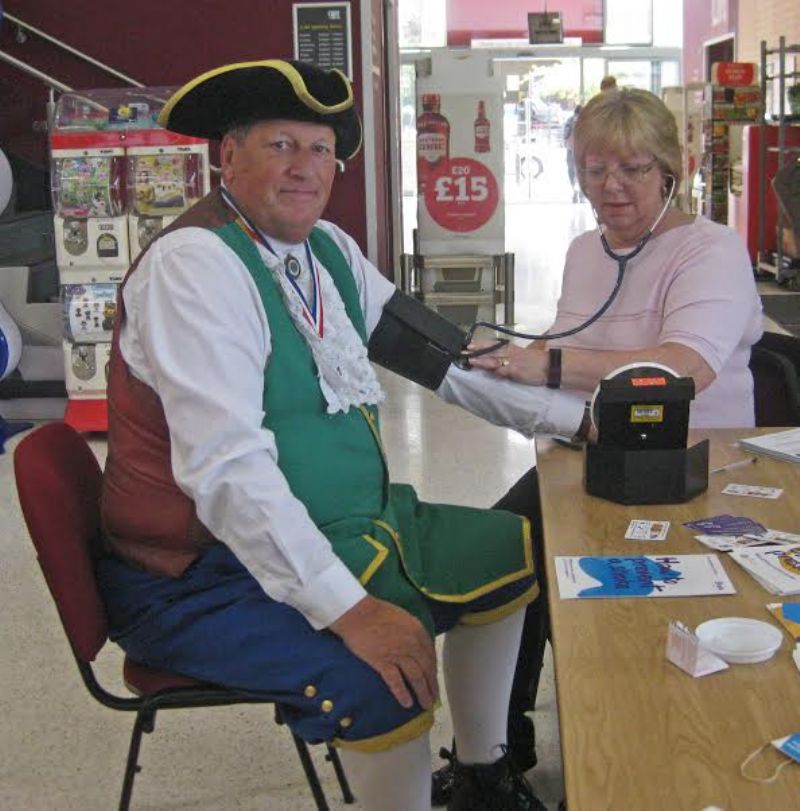 Biddulph Town Crier and Biddulph Rotarian, John Robinson, having his blood pressure taken by Nurse Practitioner, Leslie Lomas.